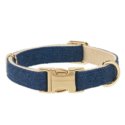 A navy blue herringbone woven dog collar with a gold-tone buckle and D-ring, shown on a plain white background.