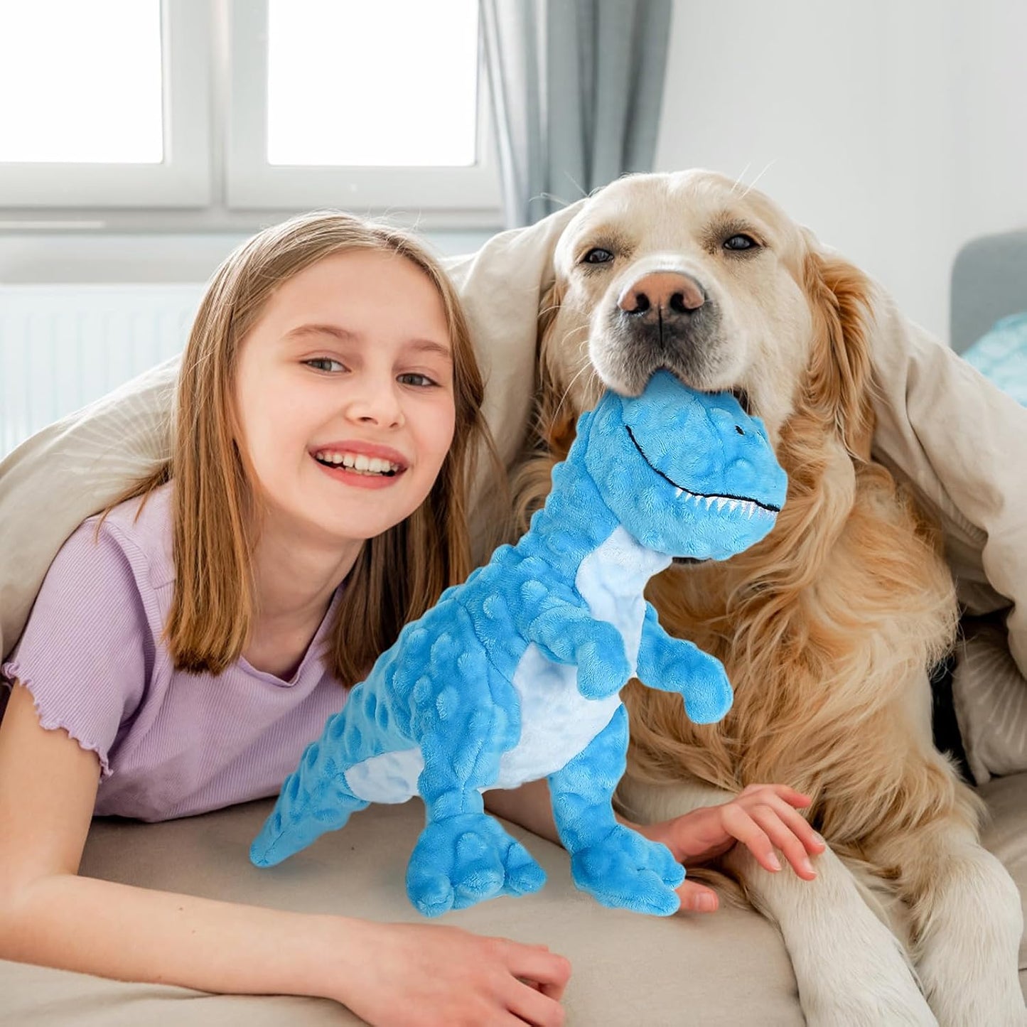 Girl and dog with a blue dinosaur-shaped toy on a couch